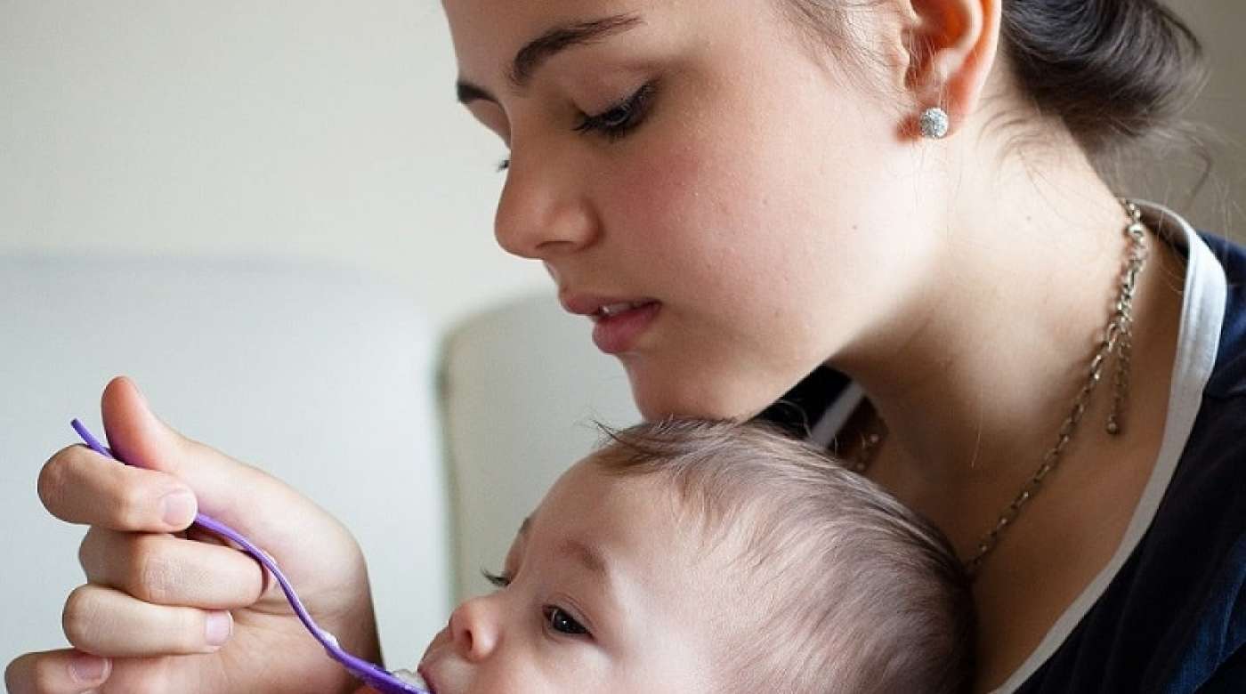 Young mom feeding her child